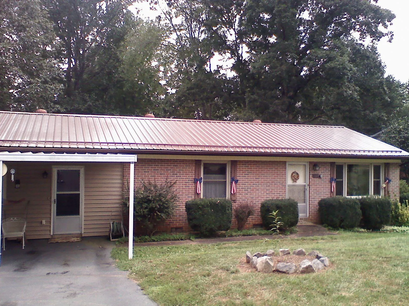 Bronze metal roof and carport on a brick ranch home — Roof Repair work by our crew in Rock Island
